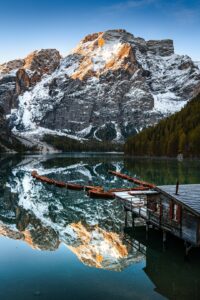 A mountain range is reflected in the still water of a lake